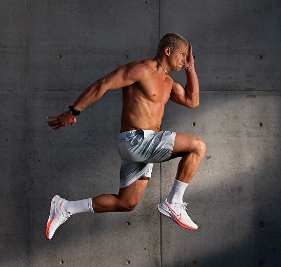 Athlete mid-stride against a concrete wall